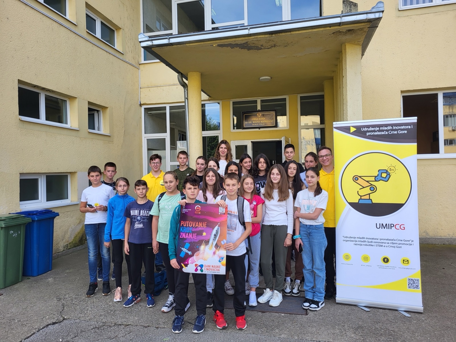 Pupils in front of a school in Bijelo Polje with the LEGO Knowledge Caravan poster